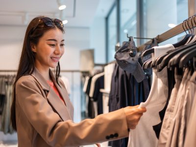 Asian beautiful young women look to product of clothes in shopping mall. Asian beautiful young women look to product of clothes in shopping mall.